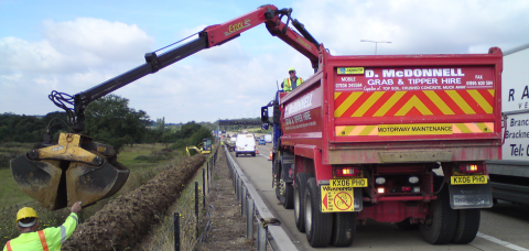 Grab tipper working from motorway hard shoulder.